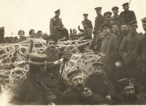 Soldados europeus reunidos próximos ao arame farpado na Frente Ocidental durante o Natal de 1914, em um raro momento de pausa nos combates da Primeira Guerra Mundial.
