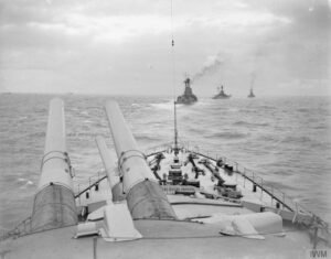 Navios de guerra da Marinha Real Britânica navegando em formação no início da Primeira Guerra Mundial, em 1914, simbolizando a confiança no poder militar e na ideia de um conflito rápido.